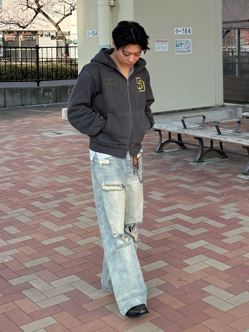 ブルー系のデニムパンツ、ブラック系のパーカー、グレー系のローファーを着用したメンズの春コーディネートの2枚目の写真