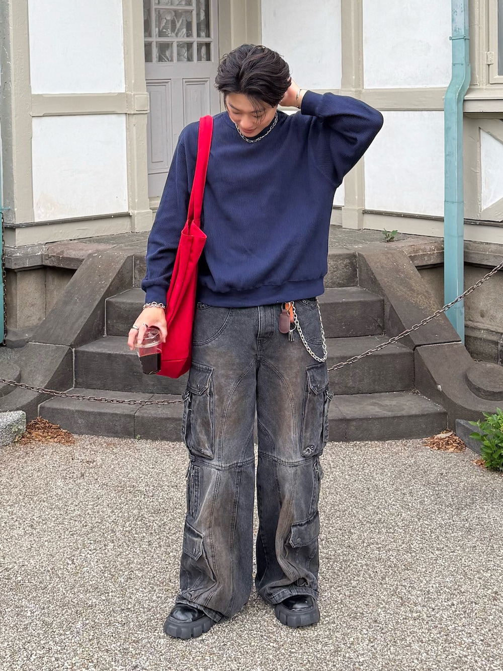 ブルー系のスウェット、ブラック系のデニムパンツ、ブラック系のブーツを着用したメンズの春コーディネートの3枚目の写真