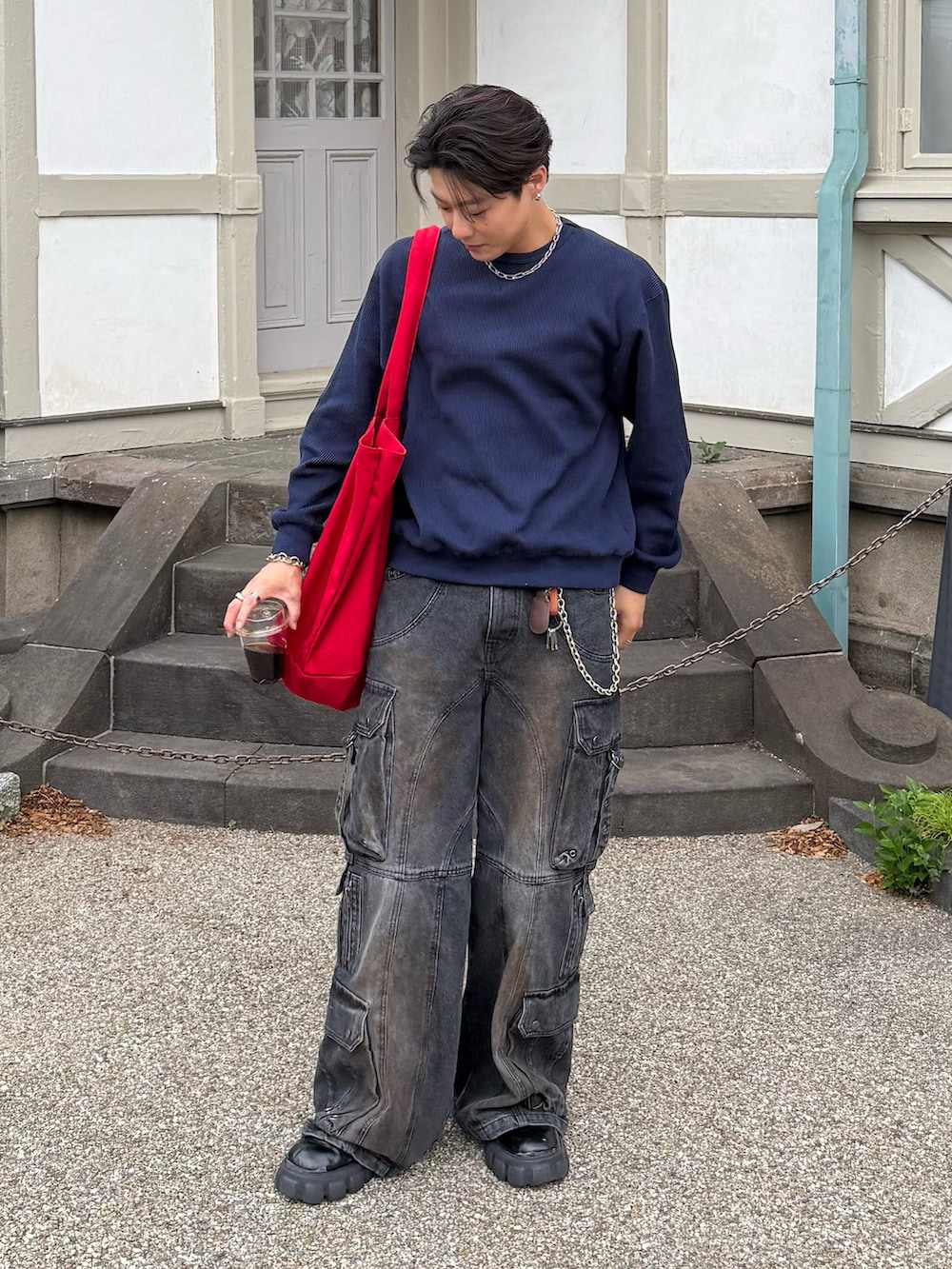 ブルー系のスウェット、ブラック系のデニムパンツ、ブラック系のブーツを着用したメンズの春コーディネートの5枚目の写真