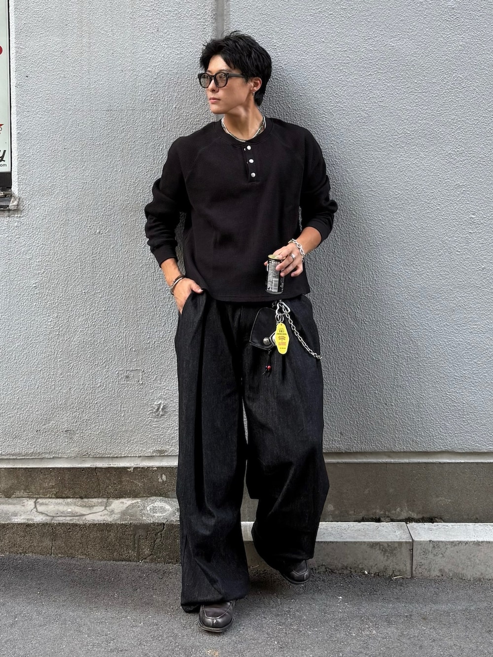 ブラック系のデニムパンツ、ブラック系のTシャツ/カットソー、グレー系のローファーを着用したメンズの秋コーディネートの2枚目の写真