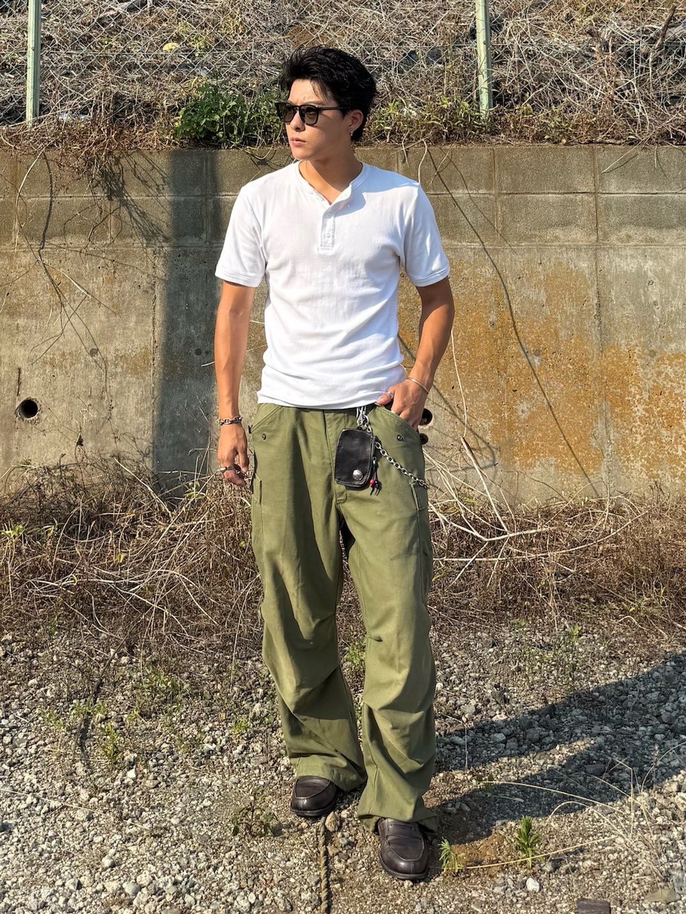 ホワイト系のTシャツ/カットソー、グレー系のローファー、グリーン系のパンツを着用したメンズの夏コーディネートの4枚目の写真