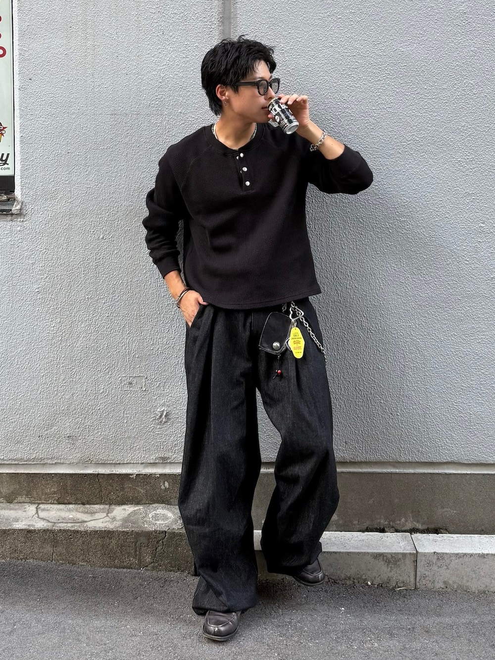 ブラック系のデニムパンツ、ブラック系のTシャツ/カットソー、グレー系のローファーを着用したメンズの秋コーディネートの3枚目の写真