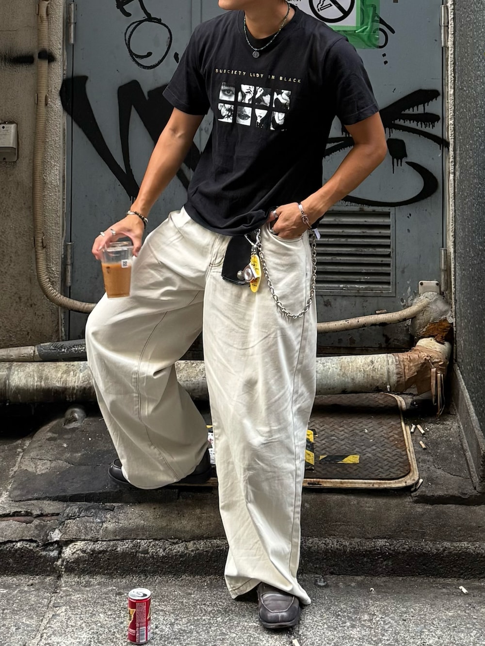 ブラック系のTシャツ/カットソー、ベージュ系のスラックス、グレー系のローファーを着用したメンズの夏コーディネートの2枚目の写真