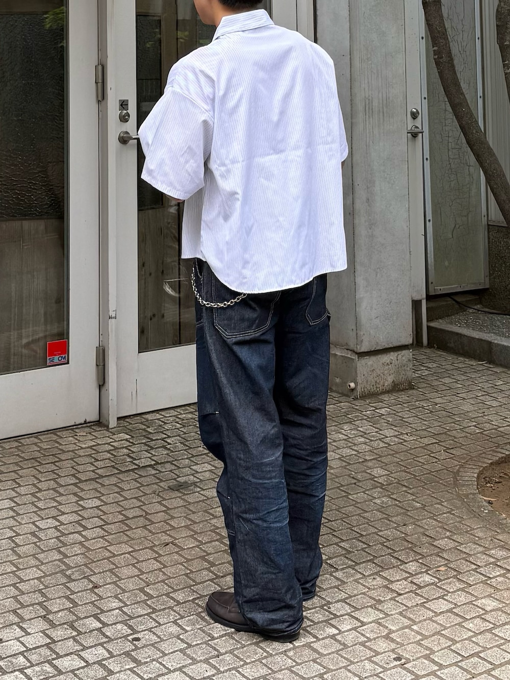 ホワイト系のシャツ/ブラウス、ブルー系のデニムパンツ、グレー系のローファーを着用したメンズの夏コーディネートの3枚目の写真