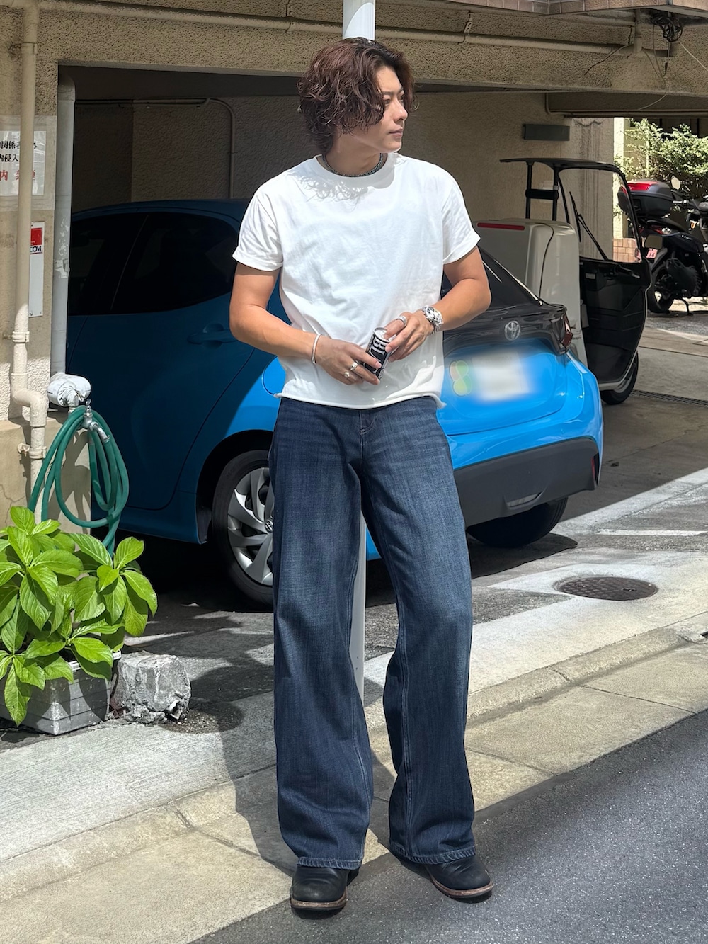 ホワイト系のTシャツ/カットソー、ブルー系のデニムパンツ、ブラック系のブーツを着用したメンズの夏コーディネートの2枚目の写真