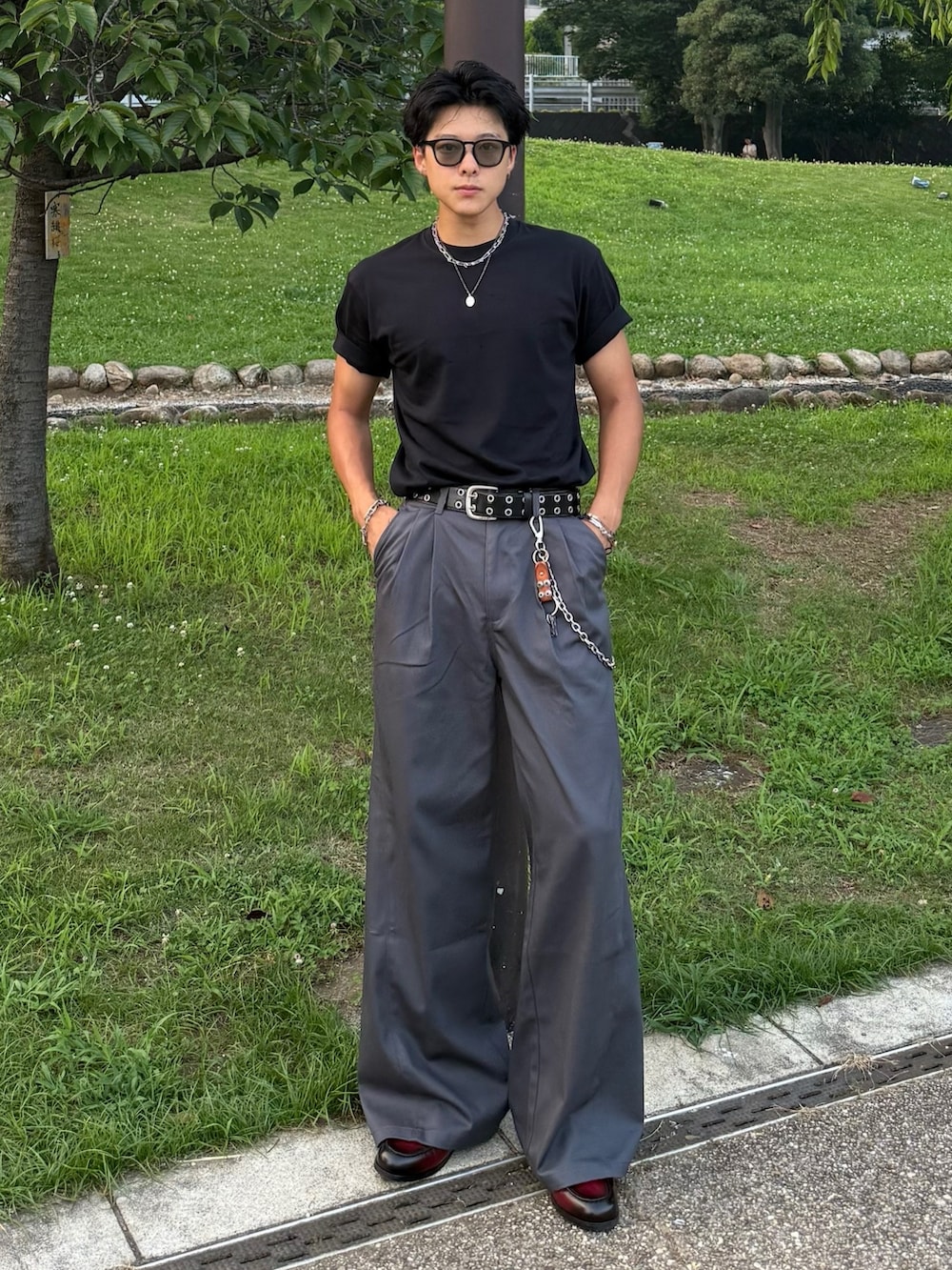 ブラック系のTシャツ/カットソー、レッド系のローファー、グレー系のチノパンツを着用したメンズの夏コーディネートの2枚目の写真