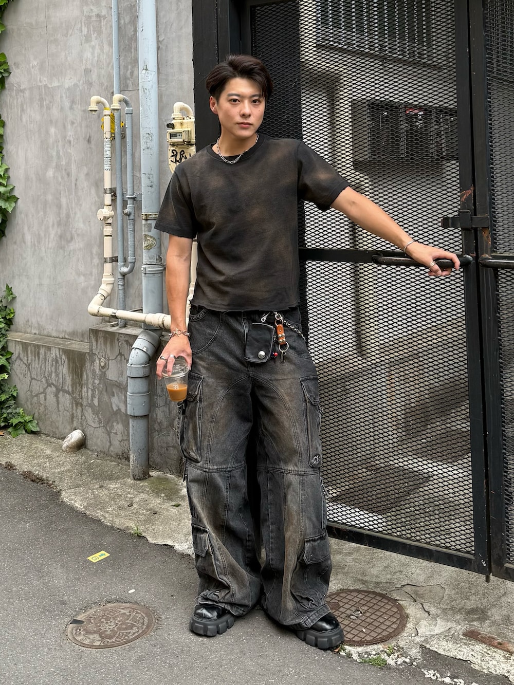 ブラック系のTシャツ/カットソー、ブラック系のデニムパンツ、ブラック系のブーツを着用したメンズの春コーディネートの2枚目の写真