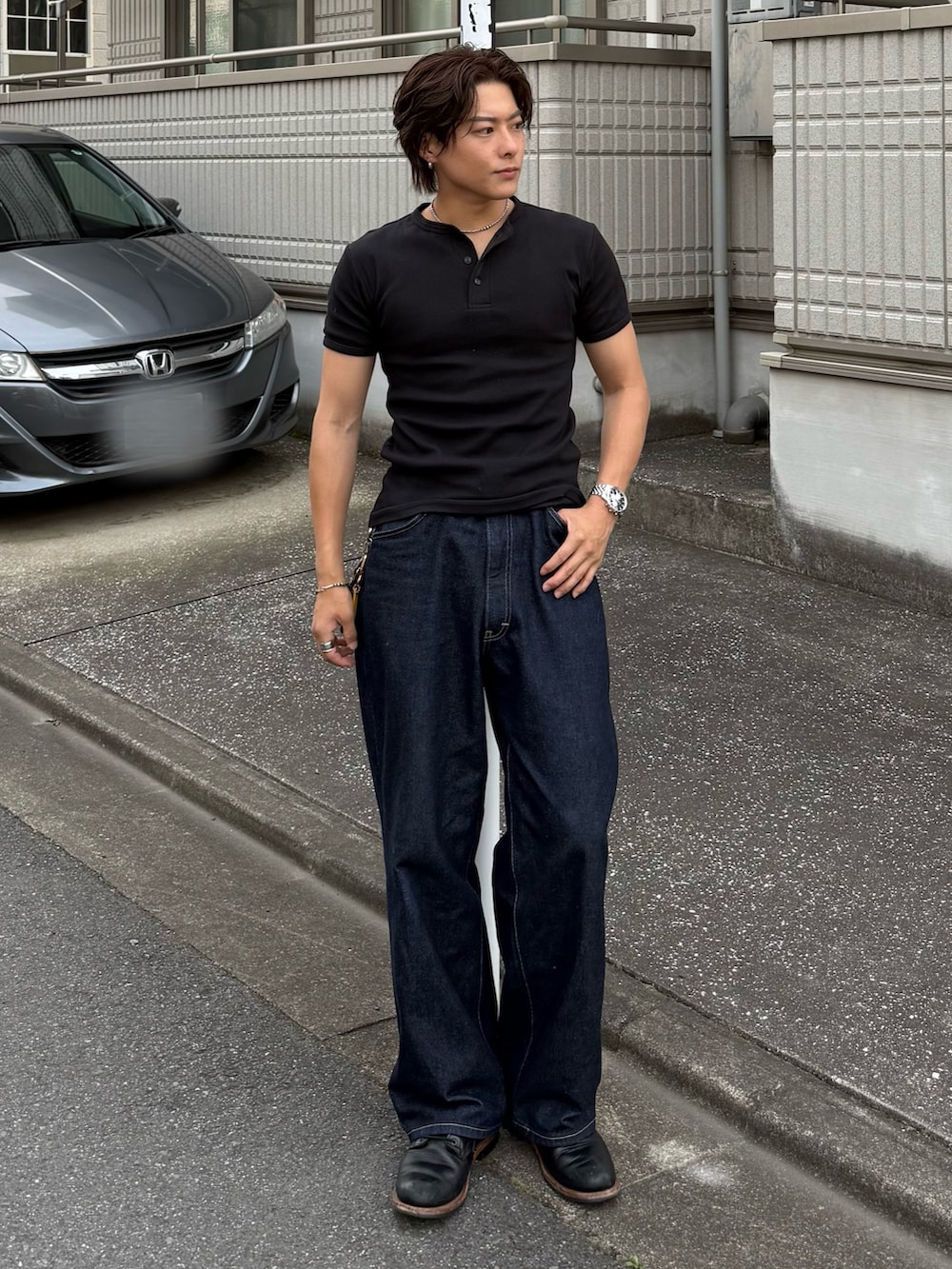 ブラック系のTシャツ/カットソー、ブルー系のデニムパンツ、ブラック系のブーツを着用したメンズの春コーディネートの2枚目の写真
