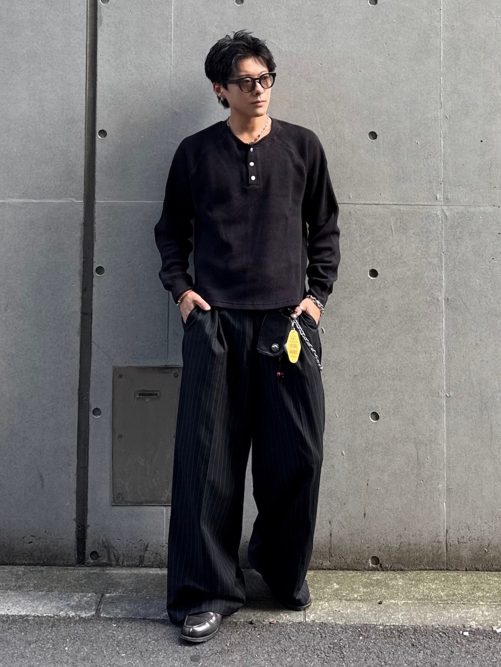 ブラック系のスラックス、ブラック系のTシャツ/カットソー、グレー系のローファーを着用したメンズの秋コーディネートの3枚目の写真