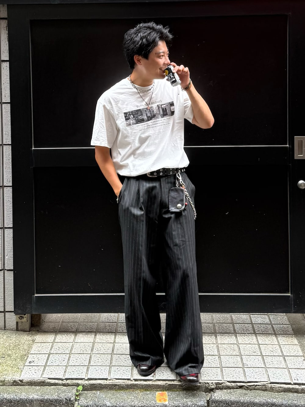 ブラック系のスラックス、レッド系のローファー、ホワイト系のTシャツ/カットソーを着用したメンズの夏コーディネートの2枚目の写真