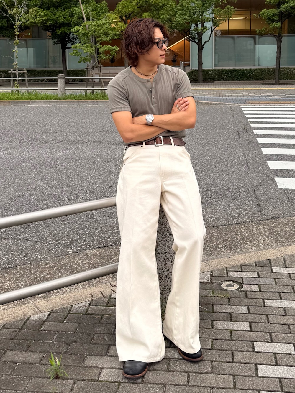 グリーン系のTシャツ/カットソー、ブラック系のブーツ、ホワイト系のデニムパンツを着用したメンズの夏コーディネートの3枚目の写真