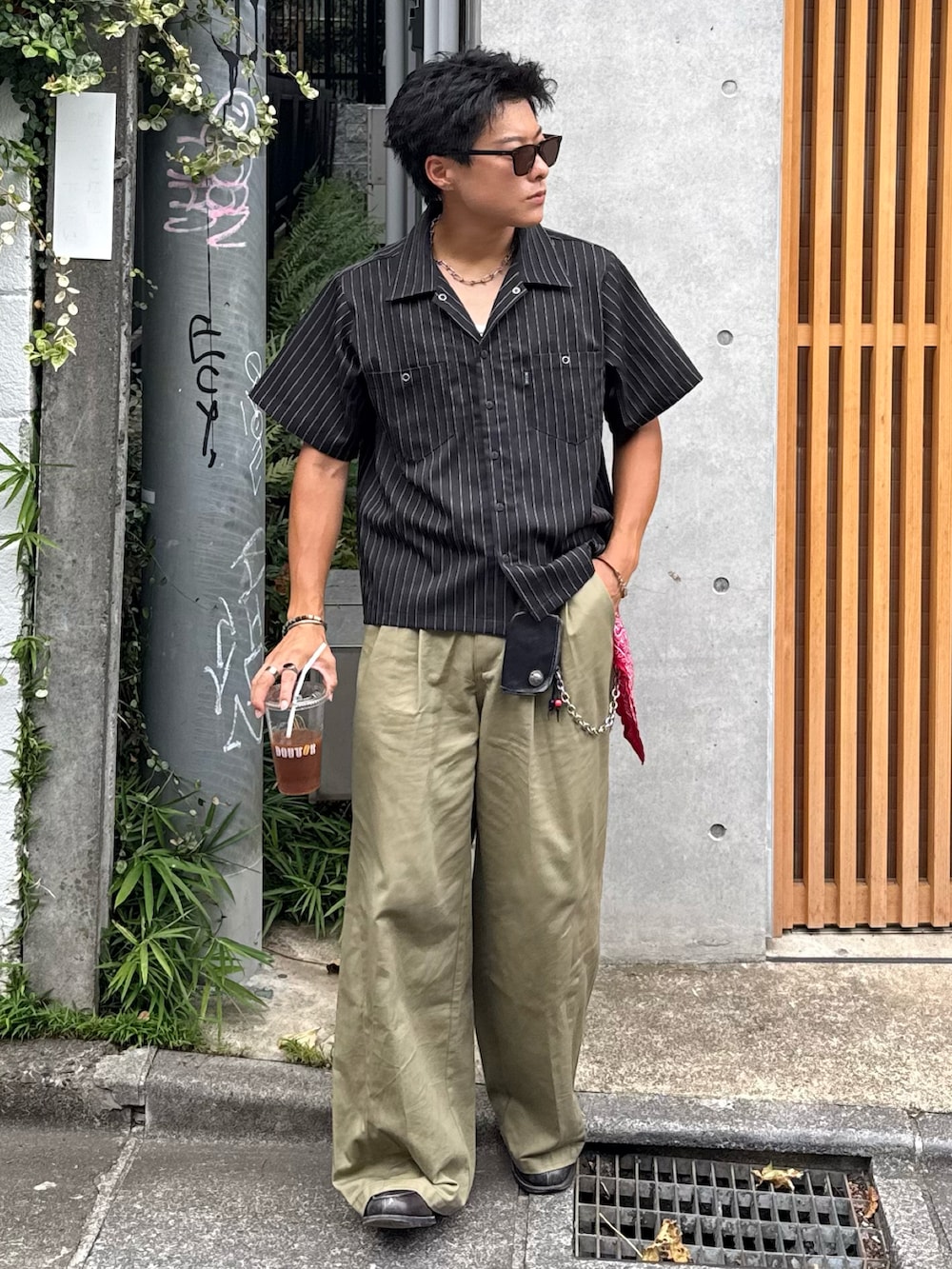 ブラック系のシャツ/ブラウス、ベージュ系のチノパンツ、グレー系のローファーを着用したメンズの夏コーディネートの3枚目の写真