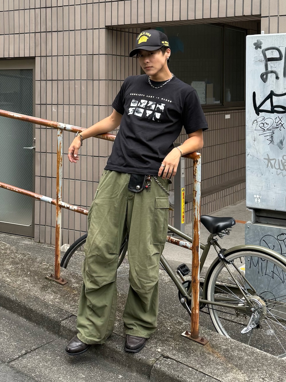 ブラック系のTシャツ/カットソー、グレー系のローファー、グレー系のキャップを着用したメンズの夏コーディネートの3枚目の写真