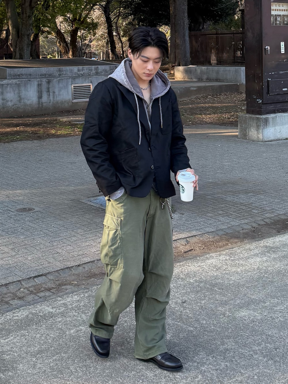 グレー系のパーカー、ブラック系のテーラードジャケット、グレー系のローファーを着用したメンズの春コーディネートの2枚目の写真
