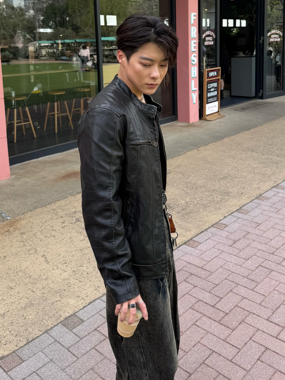 ブラック系のライダースジャケット、ブラック系のデニムパンツ、グレー系のローファーを着用したメンズの春コーディネートの3枚目の写真