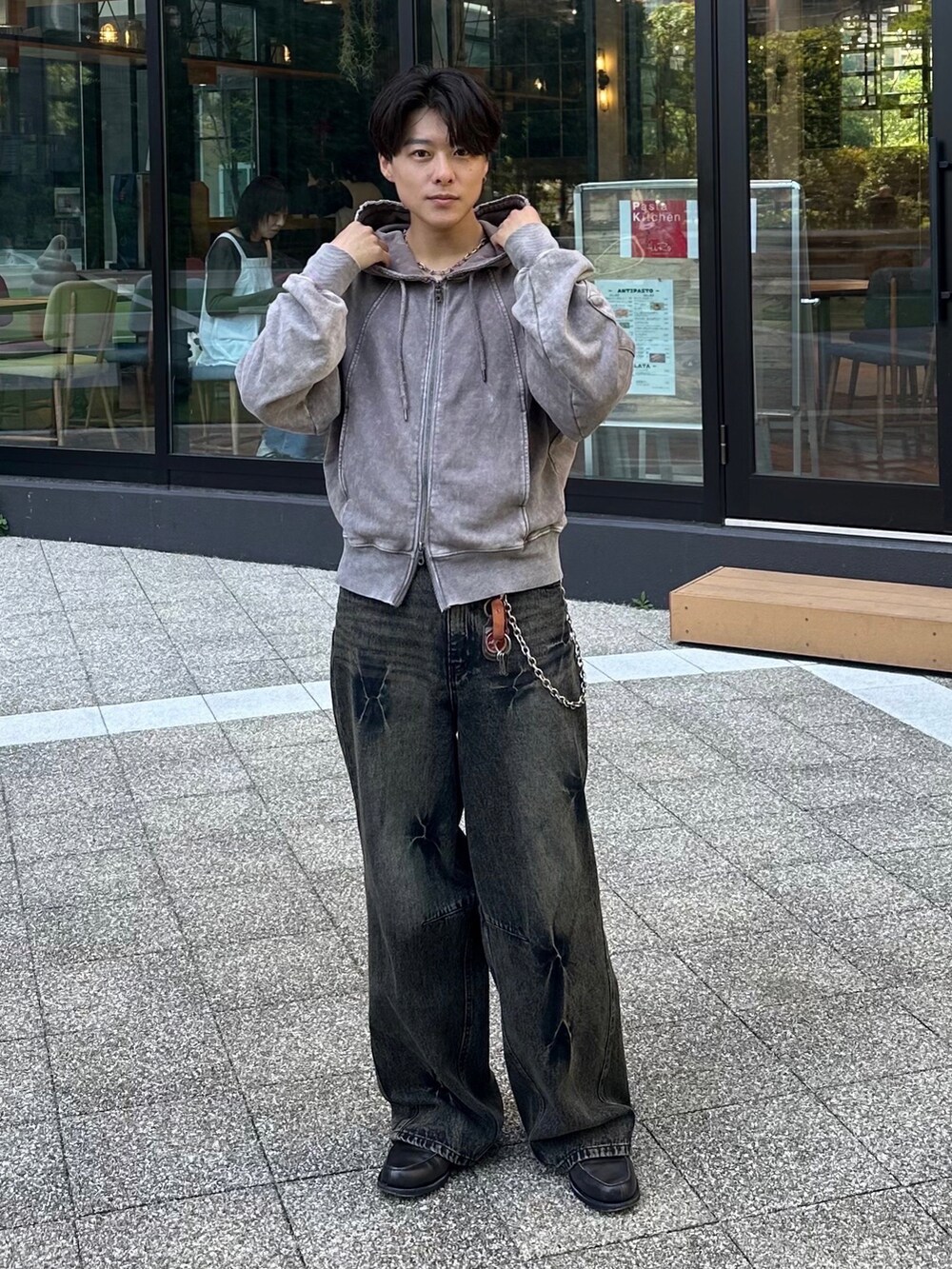 グレー系のパーカー、ブラック系のデニムパンツ、グレー系のローファーを着用したメンズの春コーディネートの3枚目の写真