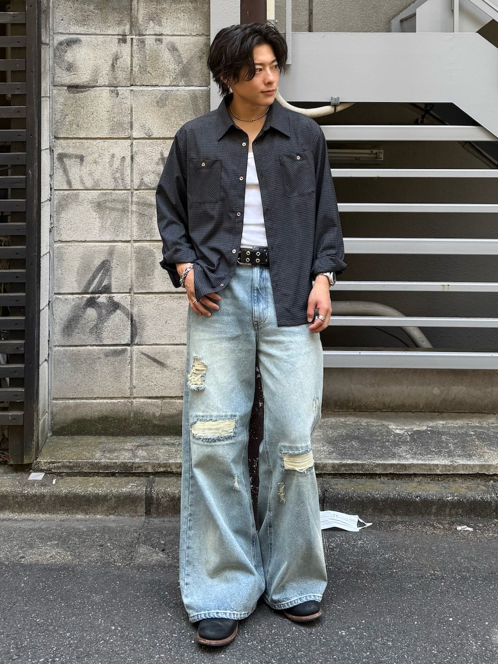 ブラック系のシャツ/ブラウス、ブルー系のデニムパンツ、ブラック系のブーツを着用したメンズの春コーディネートの2枚目の写真