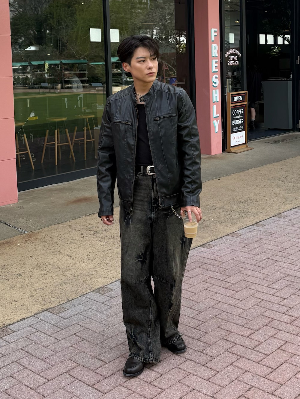 ブラック系のライダースジャケット、ブラック系のデニムパンツ、グレー系のローファーを着用したメンズの春コーディネートの2枚目の写真