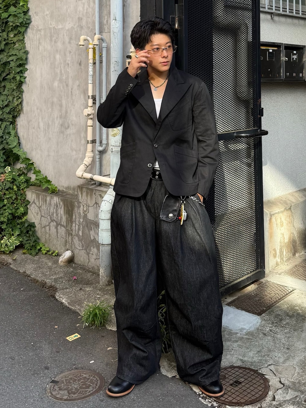 ブラック系のテーラードジャケット、ブラック系のデニムパンツ、ブラック系のブーツを着用したメンズの夏コーディネートの2枚目の写真