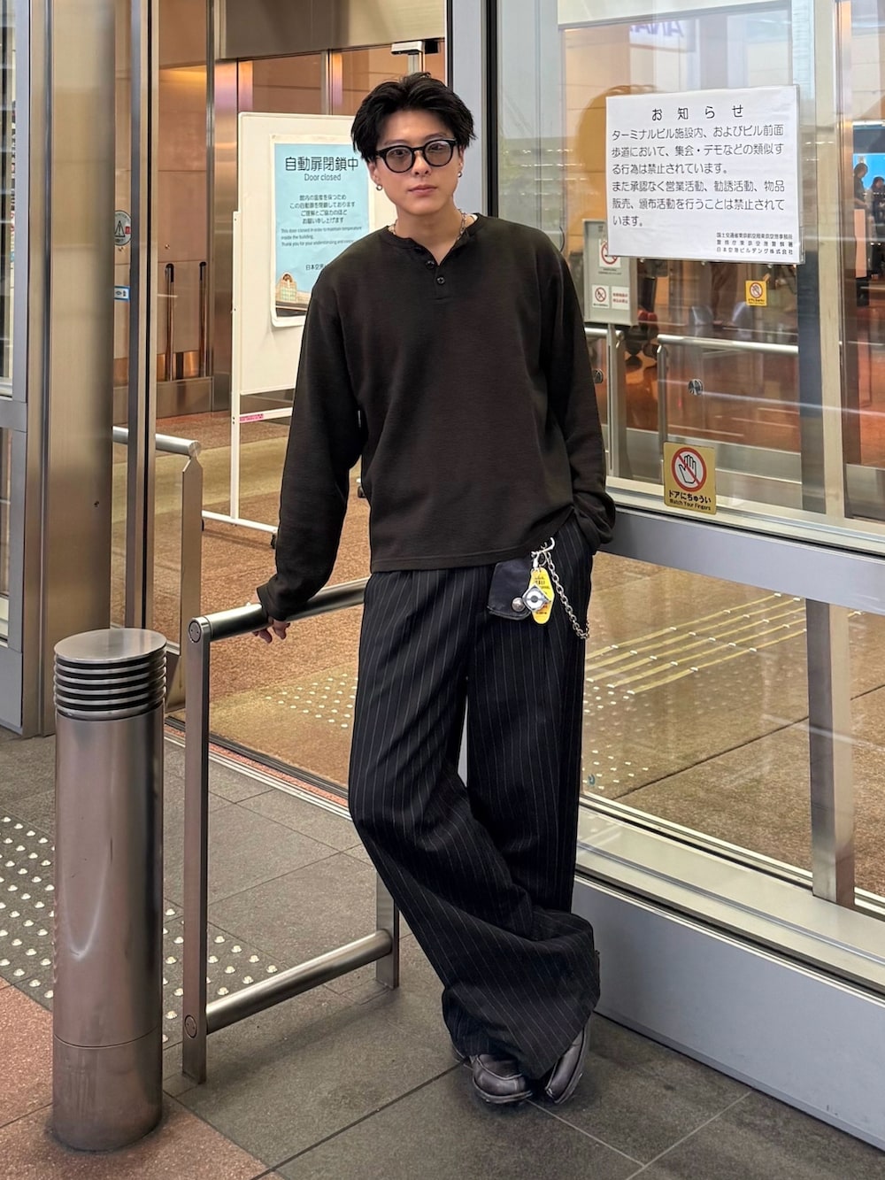 ブラック系のTシャツ/カットソー、ブラック系のスラックス、グレー系のローファーを着用したメンズの秋コーディネートの2枚目の写真