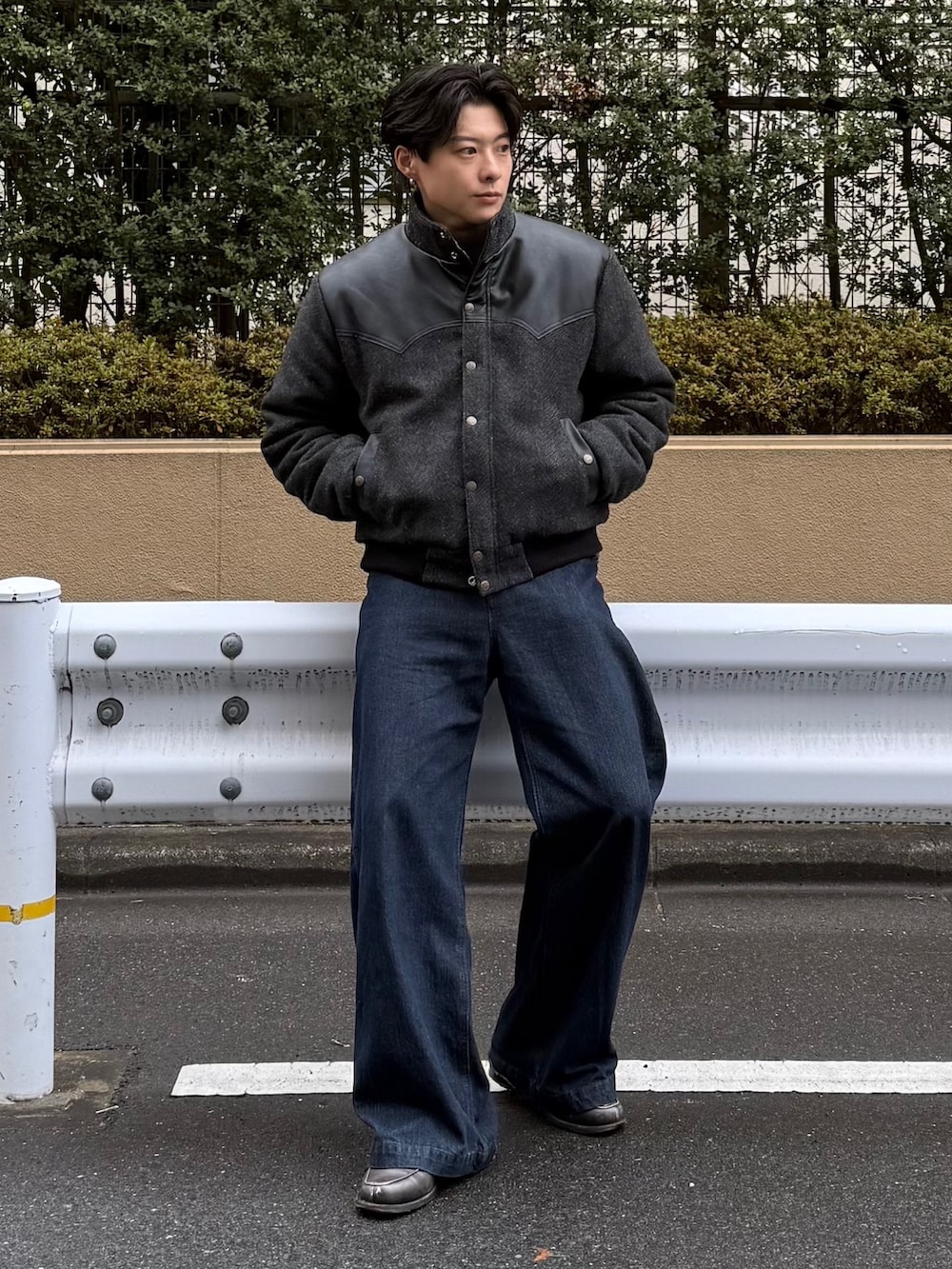 ブラック系のダウンジャケット/コート、グレー系のニット/セーター、ブルー系のデニムパンツを着用したメンズの冬コーディネートの2枚目の写真