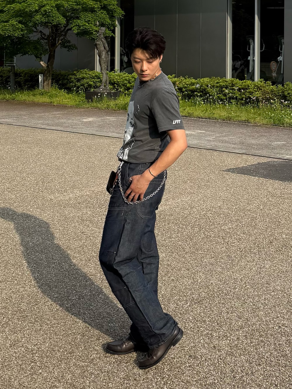 ブラック系のTシャツ/カットソー、ブルー系のデニムパンツ、グレー系のローファーを着用したメンズの春コーディネートの2枚目の写真