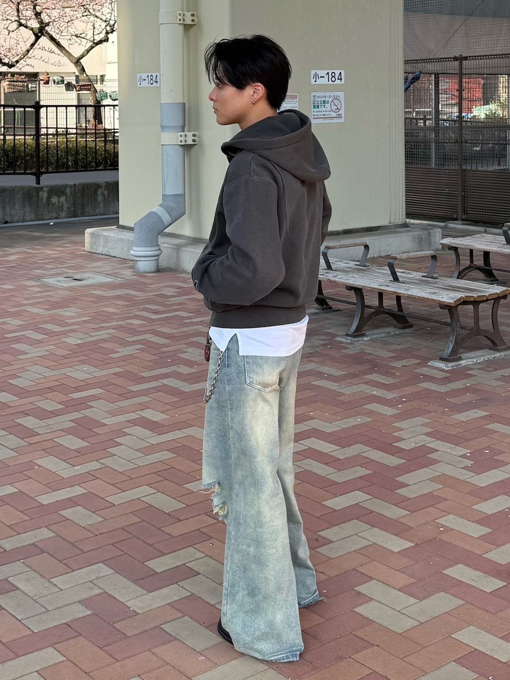 ブルー系のデニムパンツ、ブラック系のパーカー、グレー系のローファーを着用したメンズの春コーディネートの3枚目の写真