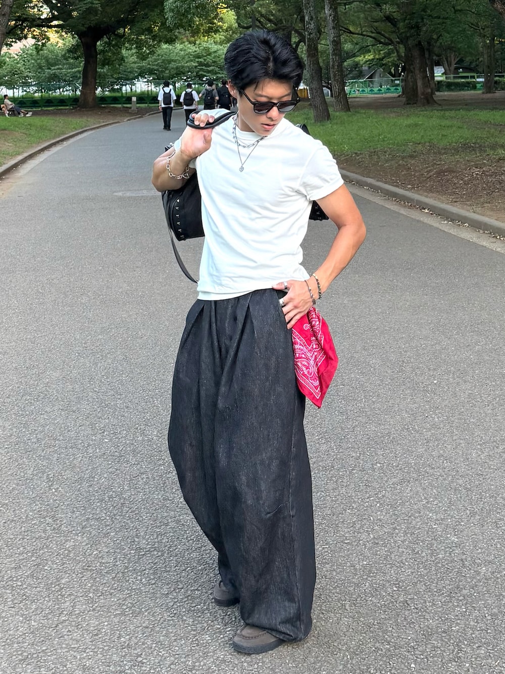 ブラック系のボストンバッグ、ホワイト系のTシャツ/カットソー、ブラック系のデニムパンツを着用したメンズの夏コーディネートの2枚目の写真