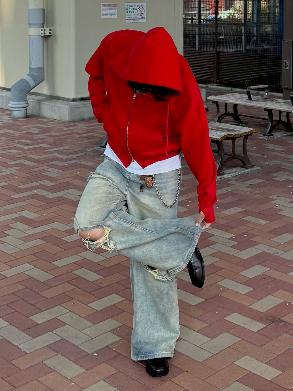 レッド系のパーカー、ブルー系のデニムパンツ、グレー系のローファーを着用したメンズの春コーディネートの2枚目の写真