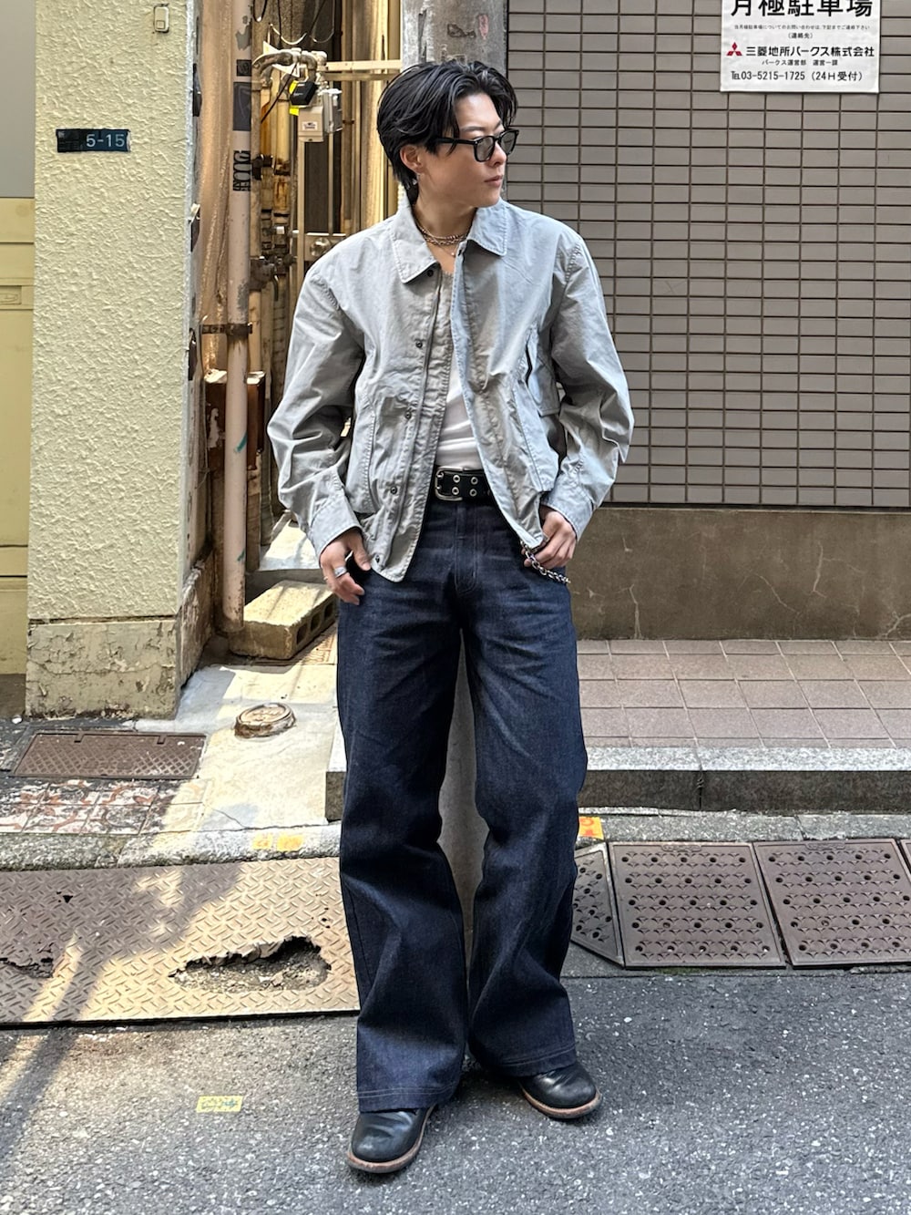 グレー系のミリタリージャケット、ブラック系のデニムパンツ、ブラック系のブーツを着用したメンズの春コーディネートの2枚目の写真