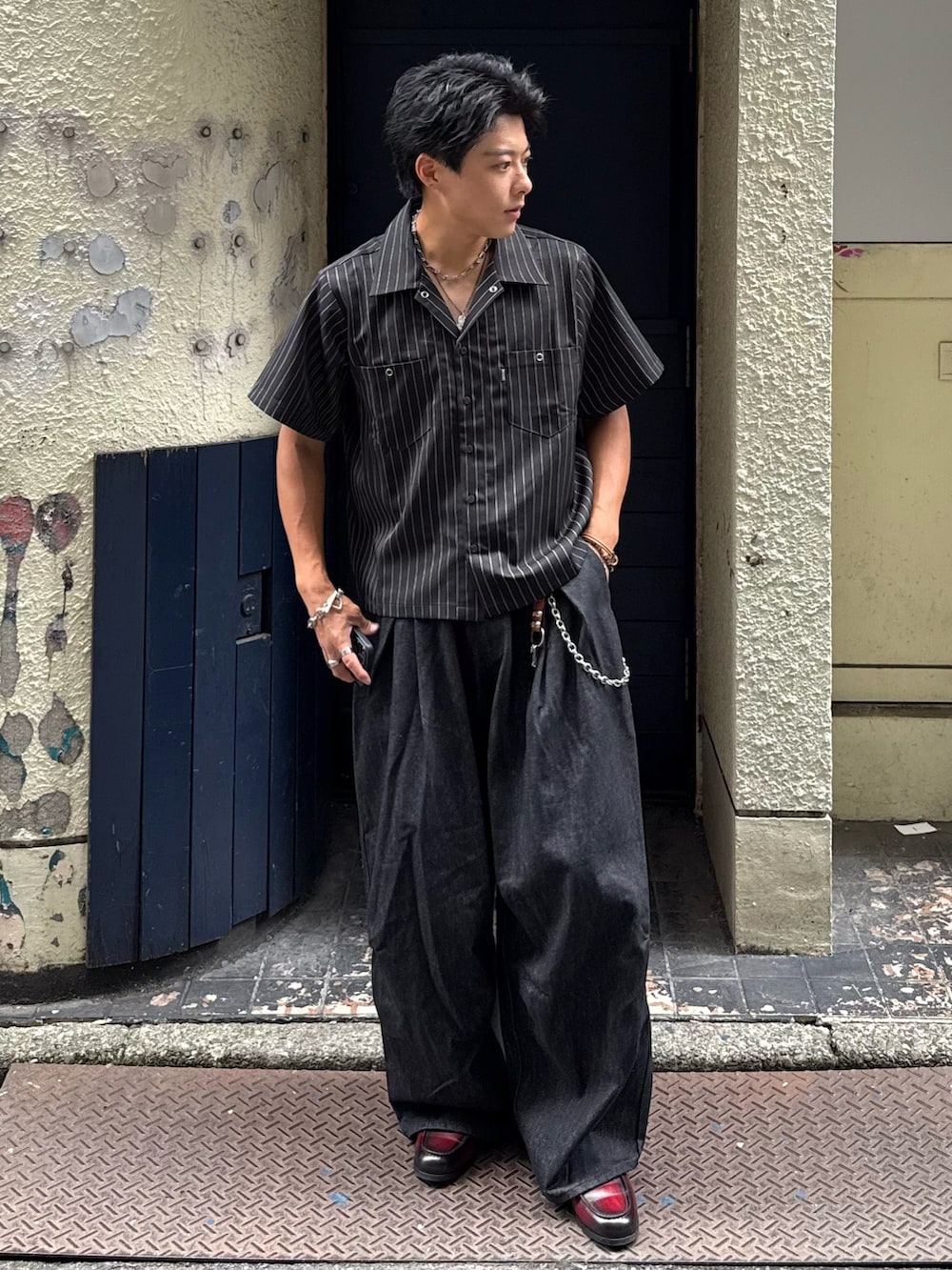 ブラック系のシャツ/ブラウス、ブラック系のデニムパンツ、レッド系のローファーを着用したメンズの夏コーディネートの2枚目の写真