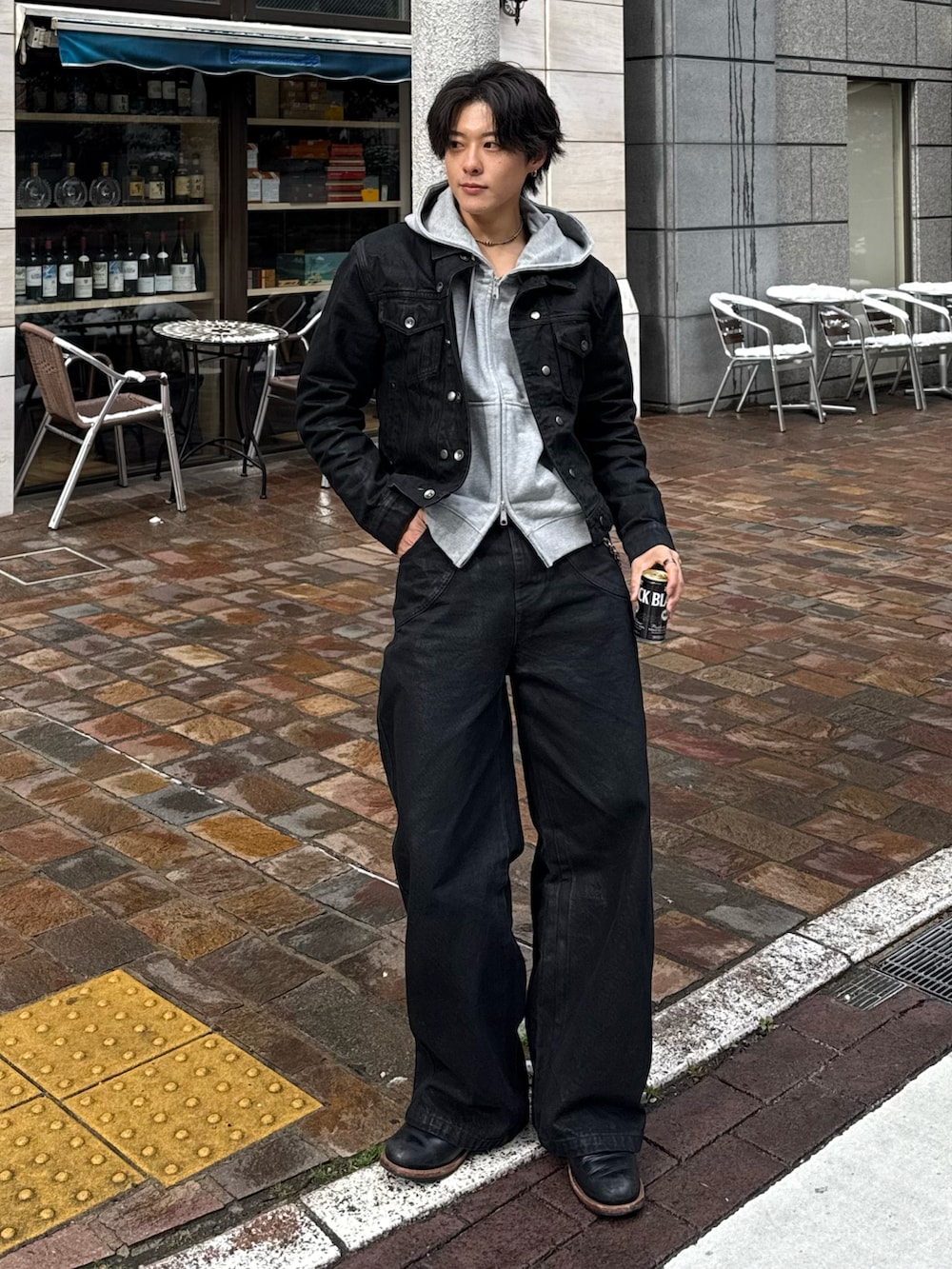 ブラック系のデニムジャケット、グレー系のパーカー、ブラック系のブーツを着用したメンズの冬コーディネートの2枚目の写真