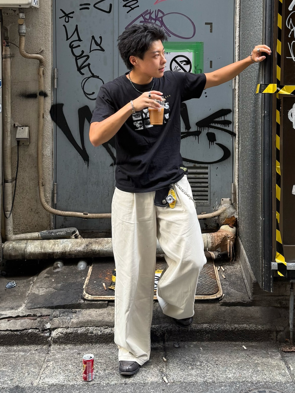 ブラック系のTシャツ/カットソー、ベージュ系のスラックス、グレー系のローファーを着用したメンズの夏コーディネートの3枚目の写真