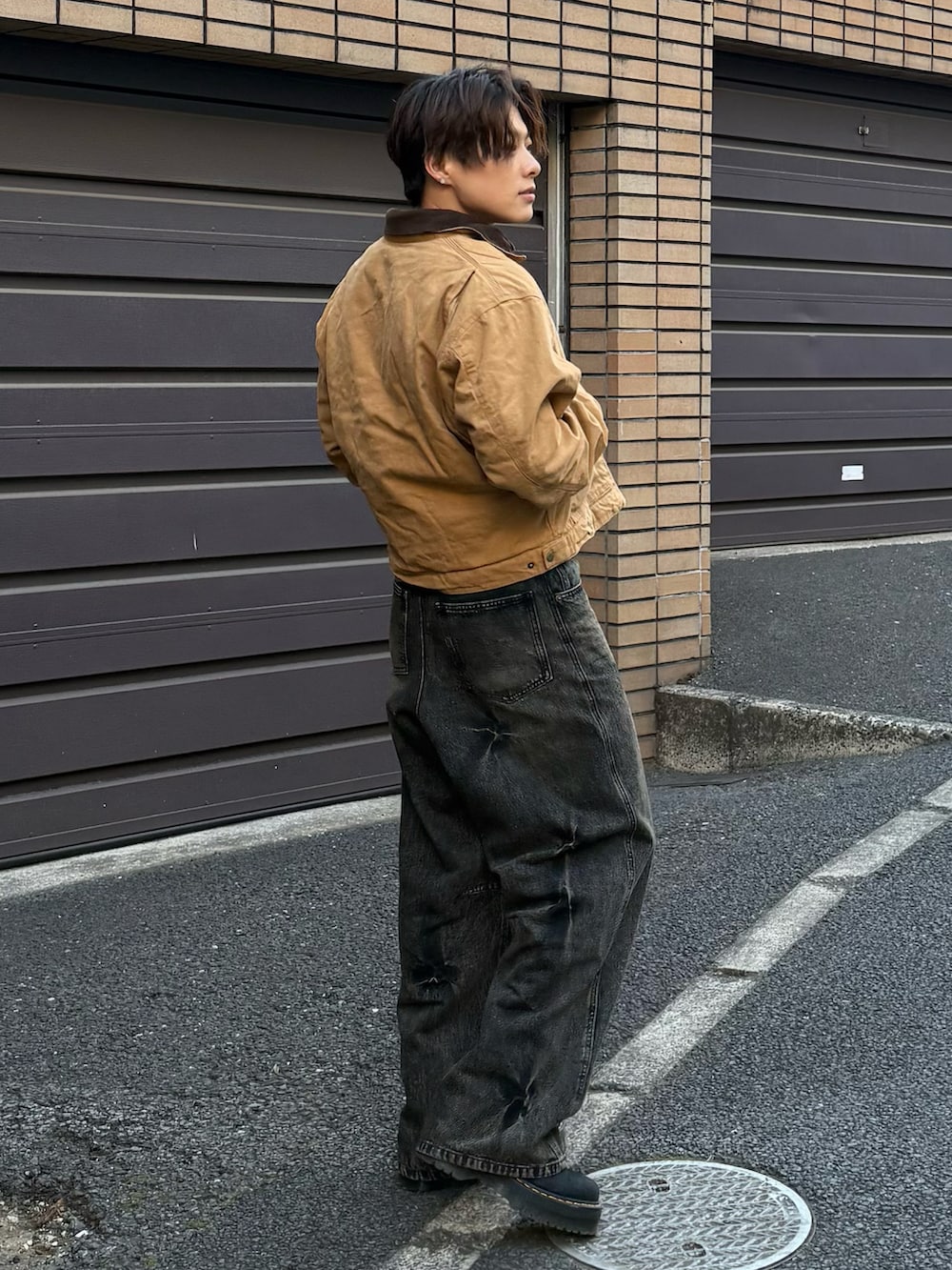 ブラック系のデニムパンツ、ブラック系のブルゾン、ブラック系のブーツを着用したメンズの冬コーディネートの3枚目の写真