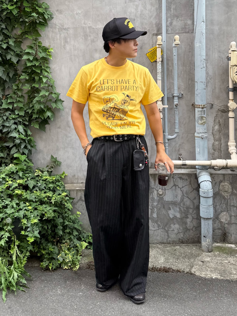 イエロー系のTシャツ/カットソー、ブラック系のスラックス、グレー系のローファーを着用したメンズの夏コーディネートの2枚目の写真