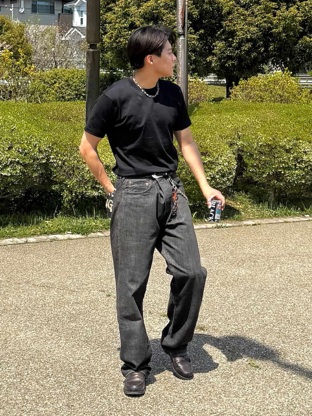 ブラック系のTシャツ/カットソー、ブラック系のデニムパンツ、グレー系のローファーを着用したメンズの春コーディネートの3枚目の写真