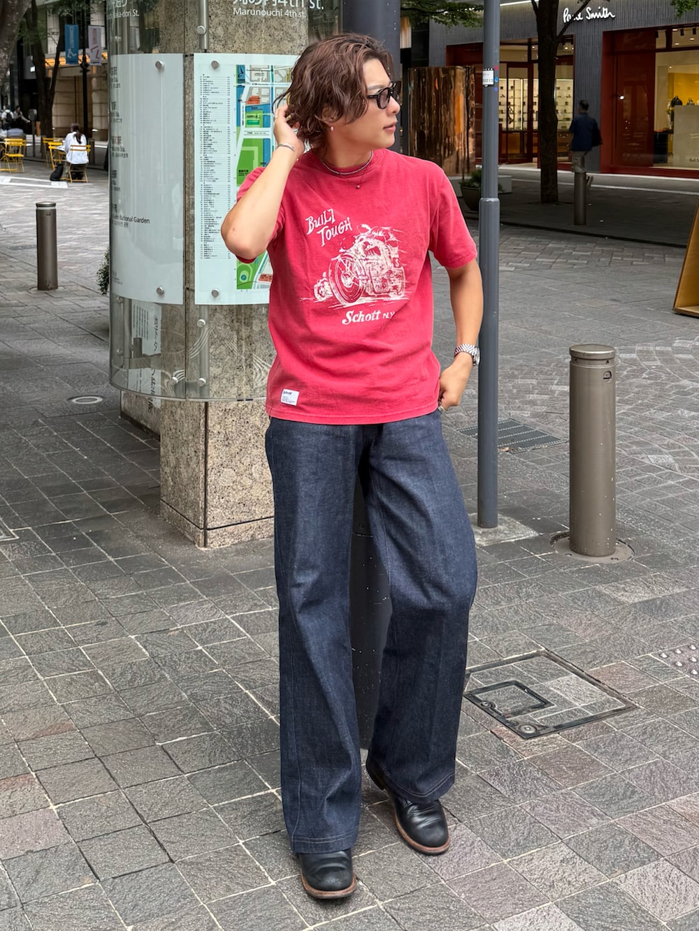 レッド系のTシャツ/カットソー、ブラック系のデニムパンツ、ブラック系のブーツを着用したメンズの夏コーディネートの2枚目の写真