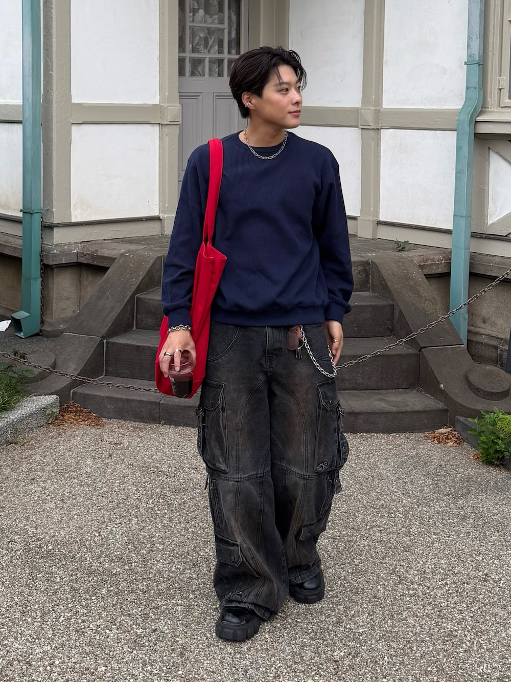 ブルー系のスウェット、ブラック系のデニムパンツ、ブラック系のブーツを着用したメンズの春コーディネートの4枚目の写真