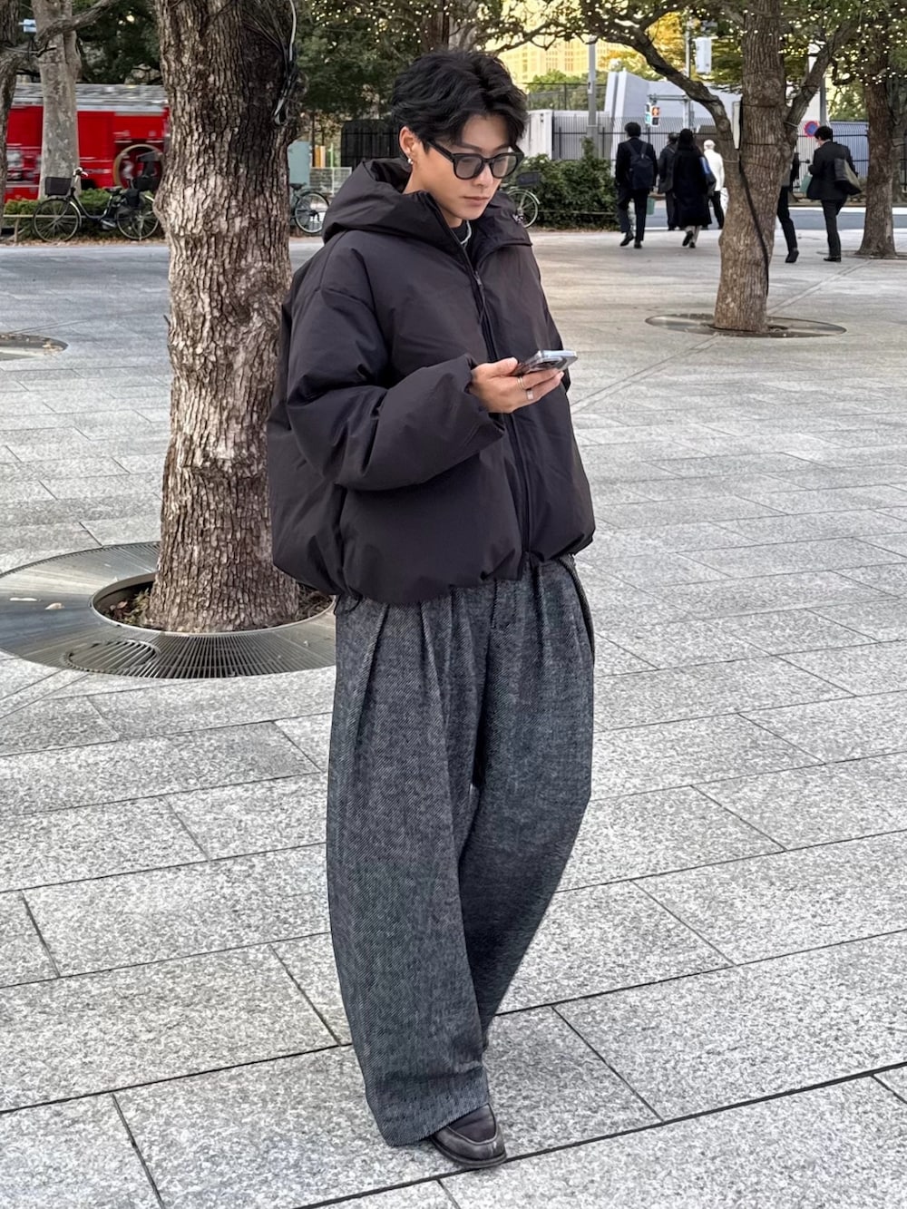 ブラック系のスウェット、ブラック系のダウンジャケット/コート、グレー系のスラックスを着用したメンズの冬コーディネートの2枚目の写真