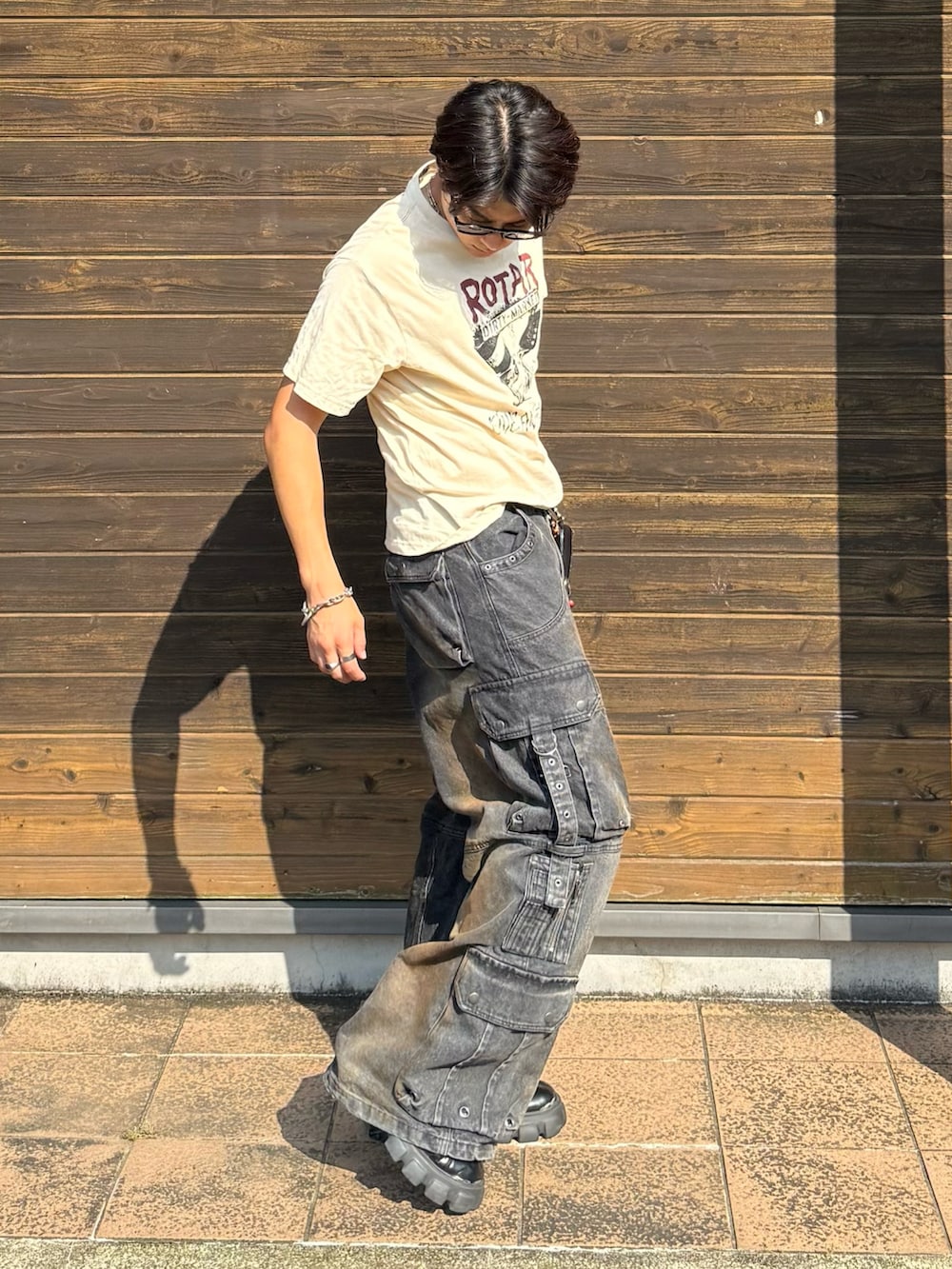 ベージュ系のTシャツ/カットソー、ブラック系のデニムパンツ、ブラック系のブーツを着用したメンズの夏コーディネートの2枚目の写真