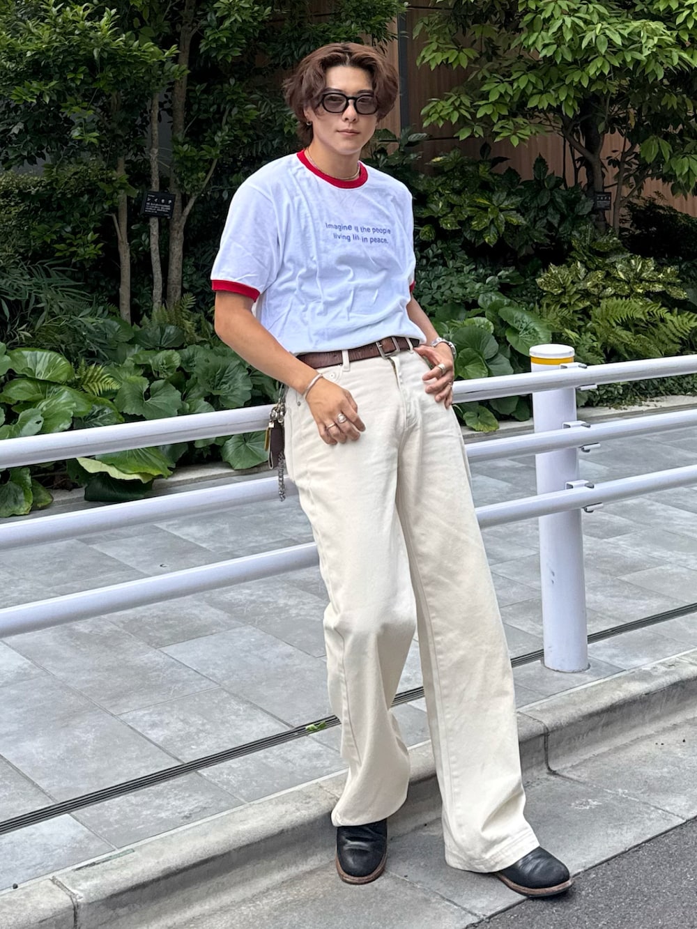 レッド系のTシャツ/カットソー、ホワイト系のデニムパンツ、ブラック系のブーツを着用したメンズの夏コーディネートの2枚目の写真