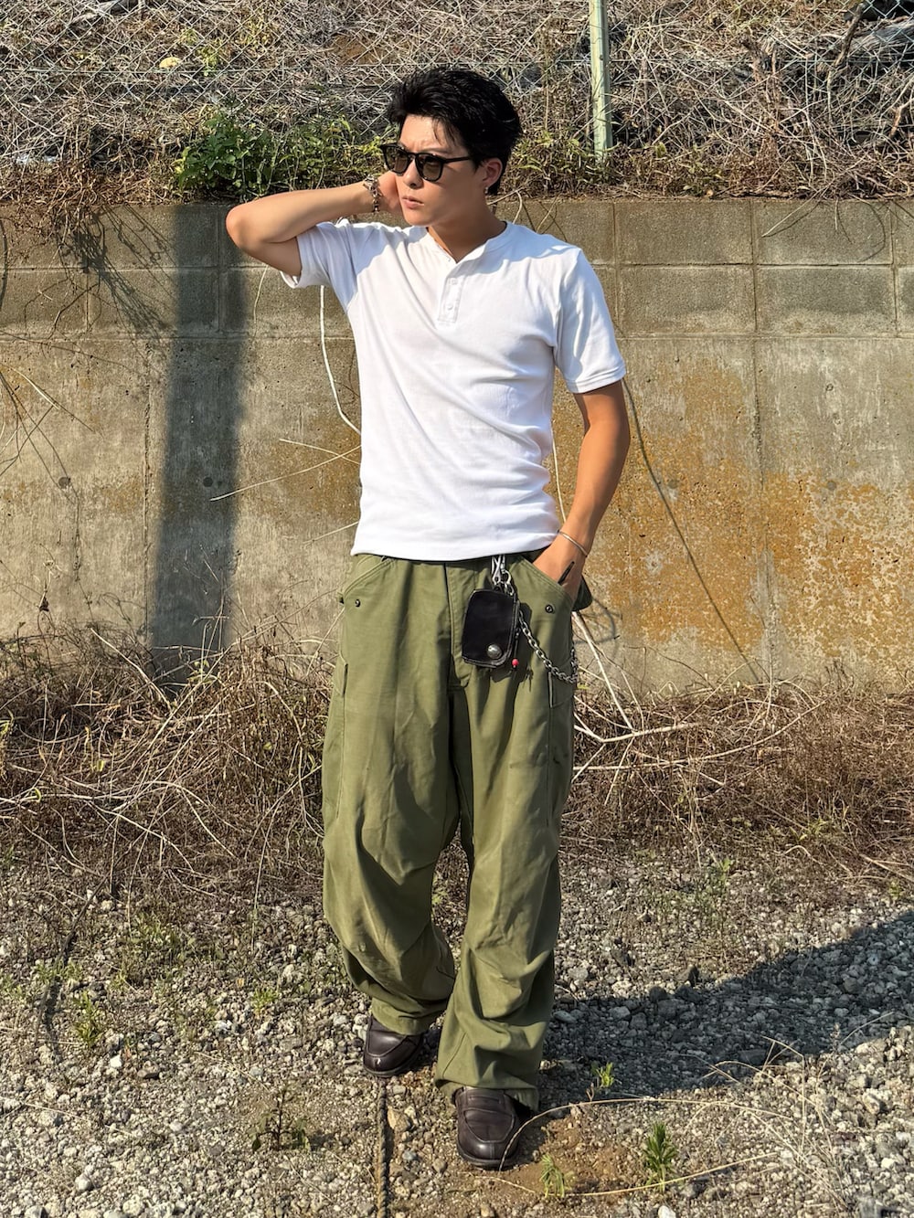 ホワイト系のTシャツ/カットソー、グレー系のローファー、グリーン系のパンツを着用したメンズの夏コーディネートの5枚目の写真