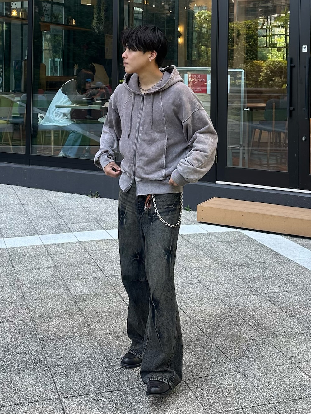 グレー系のパーカー、ブラック系のデニムパンツ、グレー系のローファーを着用したメンズの春コーディネートの2枚目の写真