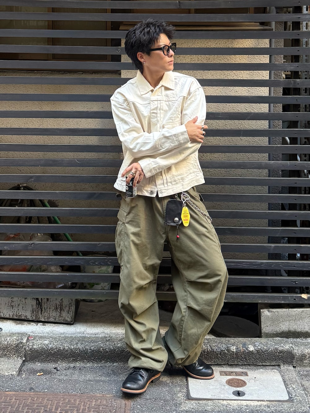 ベージュ系のデニムジャケット、グリーン系のカーゴパンツ、ブラック系のブーツを着用したメンズの秋コーディネートの2枚目の写真