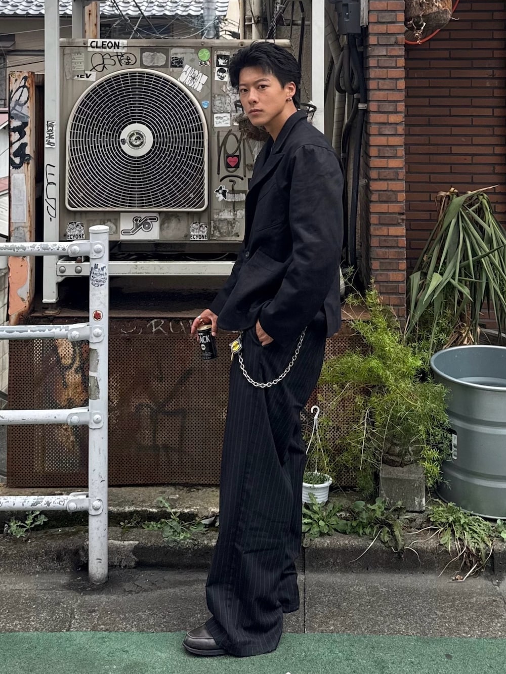 ブラック系のテーラードジャケット、ブラック系のスラックス、グレー系のローファーを着用したメンズの秋コーディネートの2枚目の写真