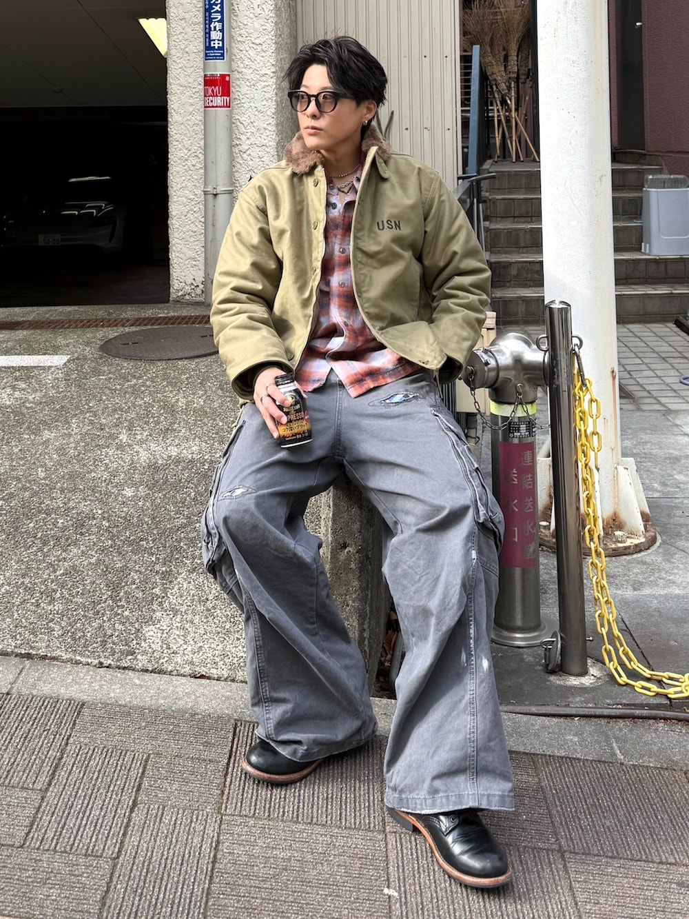 オレンジ系のシャツ/ブラウス、ベージュ系のミリタリージャケット、グレー系のパンツを着用したメンズの冬コーディネートの2枚目の写真