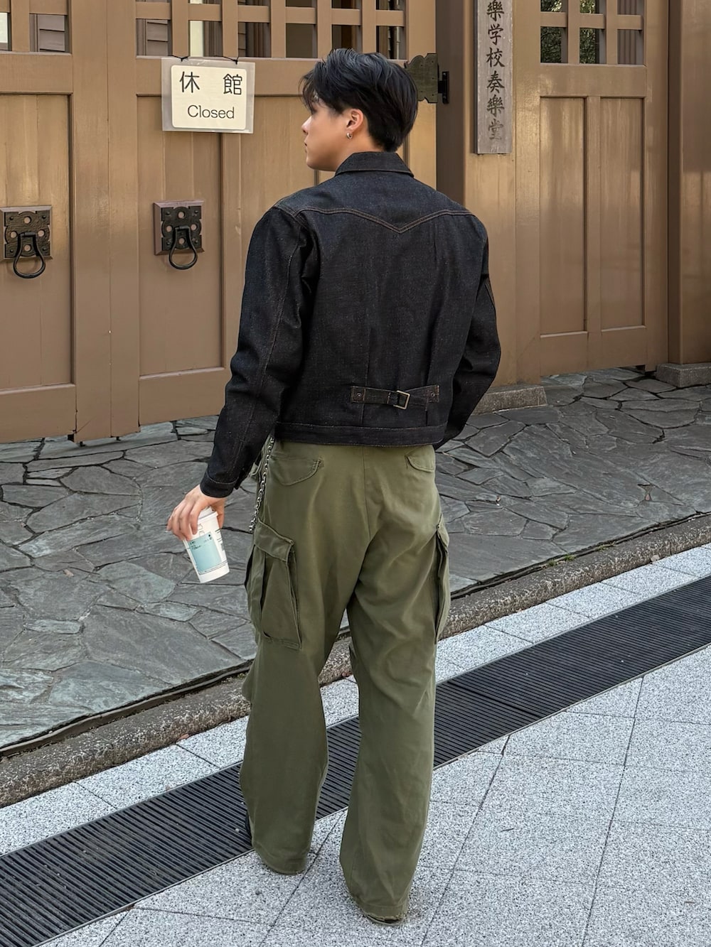 ブラック系のデニムジャケット、グレー系のローファー、グリーン系のパンツを着用したメンズの春コーディネートの4枚目の写真