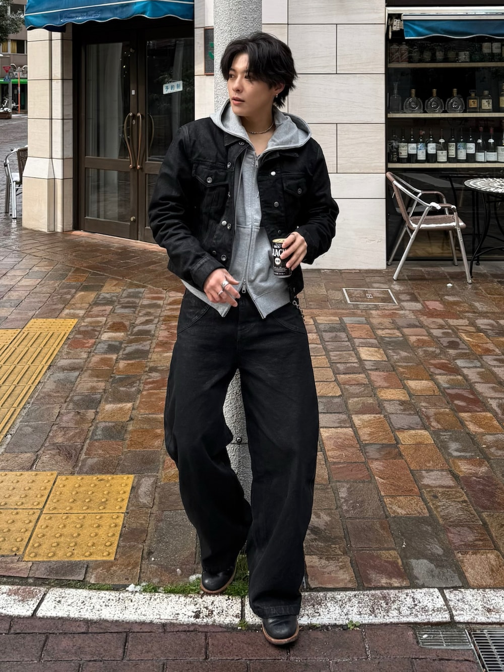 ブラック系のデニムジャケット、グレー系のパーカー、ブラック系のブーツを着用したメンズの冬コーディネートの3枚目の写真