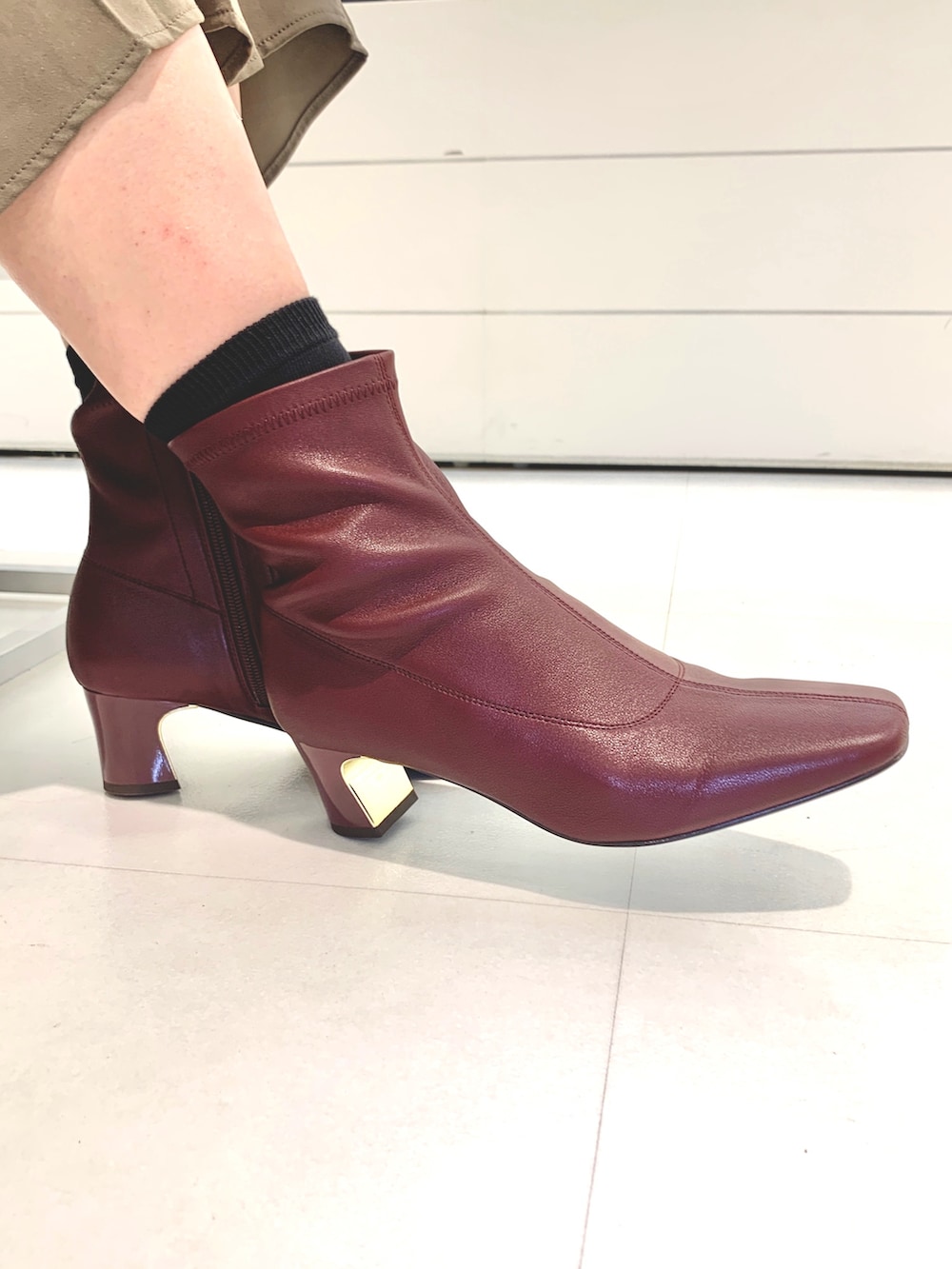 レッド系のブーツ、グリーン系のパンツ、ブルー系のシャツ/ブラウスを着用したレディースの秋コーディネートの3枚目の写真