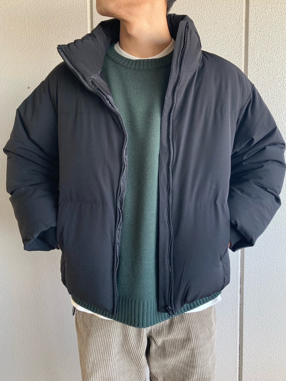 グリーン系のニット/セーターを着用したメンズの冬コーディネートの2枚目の写真